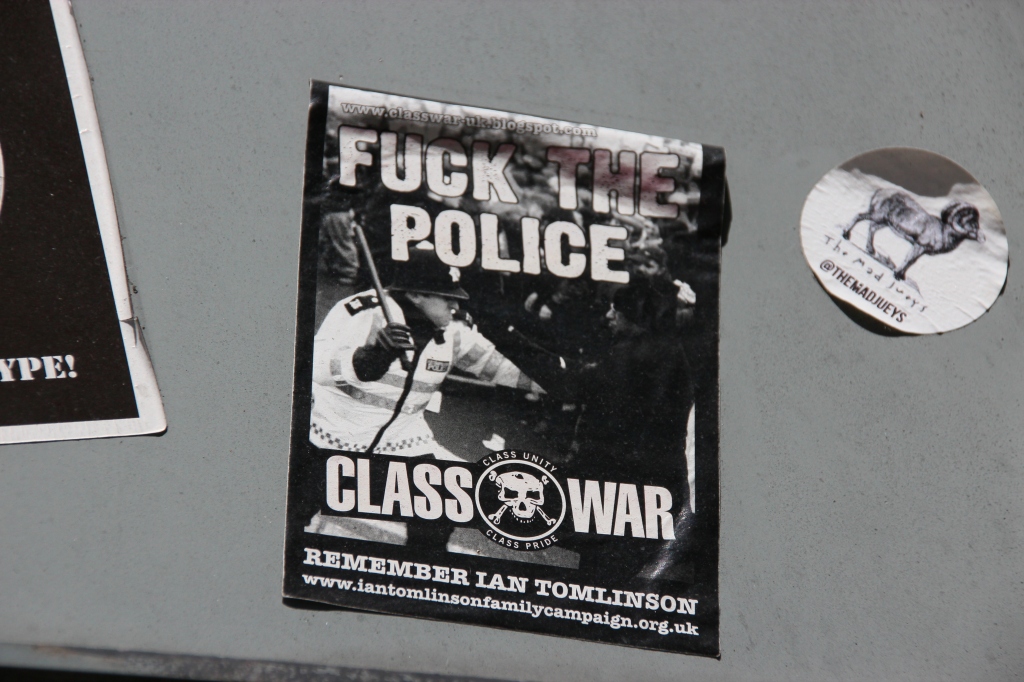This sticker also relates to a specific case. Ian Tomlinson famously collapsed and died after being struck by a police officer at the 2009 G-20 protests. AN inquest found that he had been unlawfully killed (Kennington Park Road, 04/06/15).